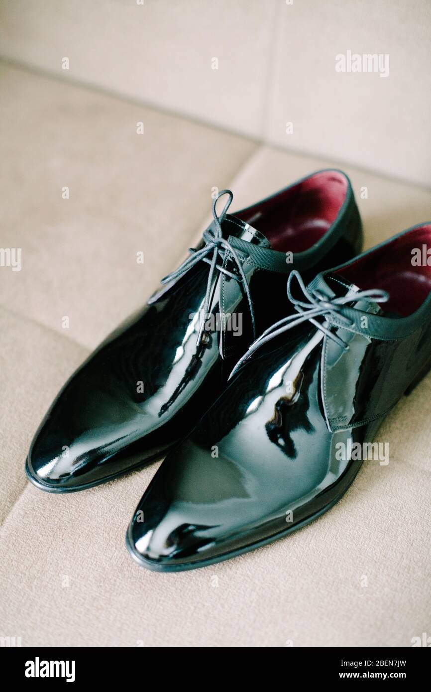 Black patent leather wedding shoes. Wedding reparations details. Indoor and close up. Stock Photo