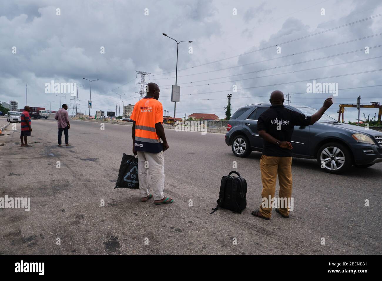 People try to flag down cars to get to their destination during Covid