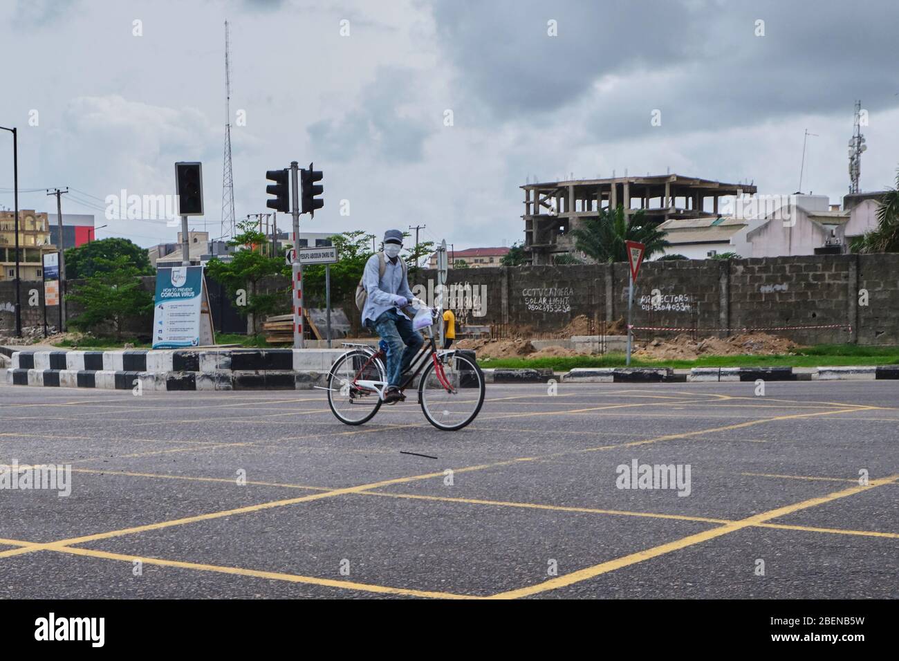 A man rides a bike across the road during the Covid-19 lockdown in Lagos, Nigeria. Stock Photo