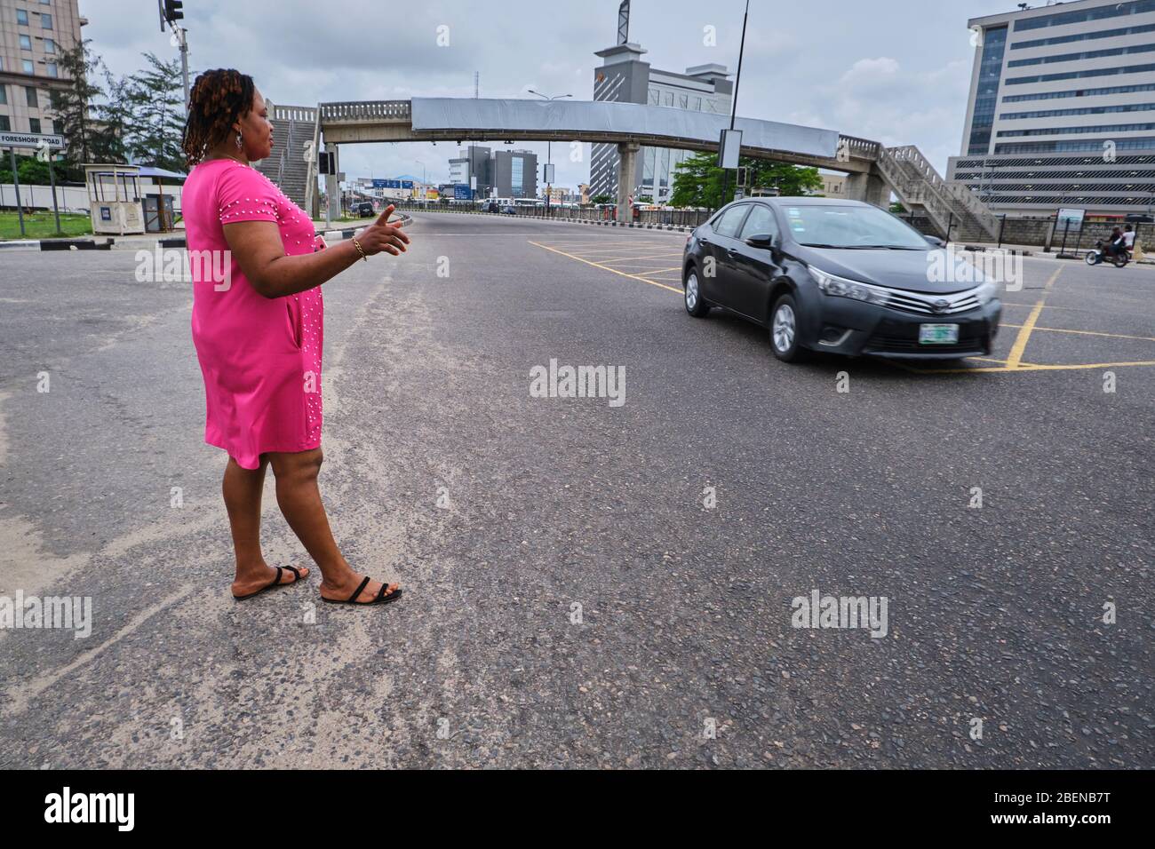 A woman tries to flag down a car during the Covid-19 lockdown in Lagos, Nigeria. Stock Photo