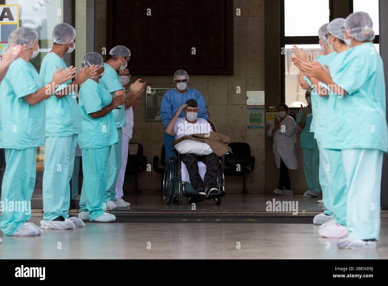 (200415) -- BRASILIA, April 15, 2020 (Xinhua) -- Ernando Piveta (C), a 99-year-old Brazilian World War II veteran, is discharged from the Armed Forces Hospital after recovering from the COVID-19 in Brasilia, Brazil, April 14, 2020. Ernando Piveta, who had been a member of the Brazilian Expeditionary Force, was admitted to the hospital on April 6 and treated in the facility's 'COVID ward' after testing positive for the virus, the Defense Ministry said. Born on Oct. 7, 1920, Piveta received the Medal of Victory from Brazil's President Jair Bolsonaro last year for his service to the nation. (Pho Stock Photo