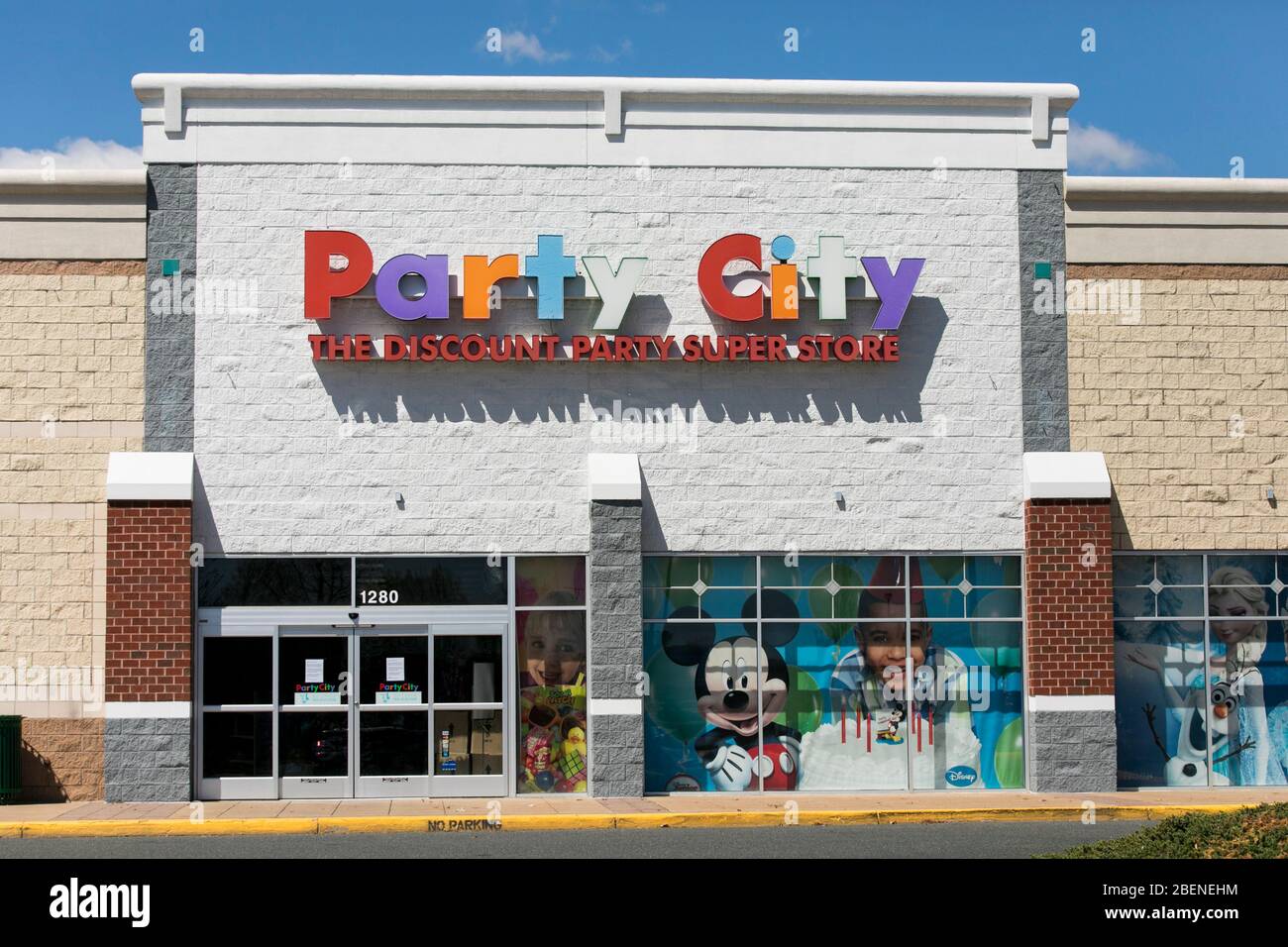 A logo sign outside of a Party City retail store location in