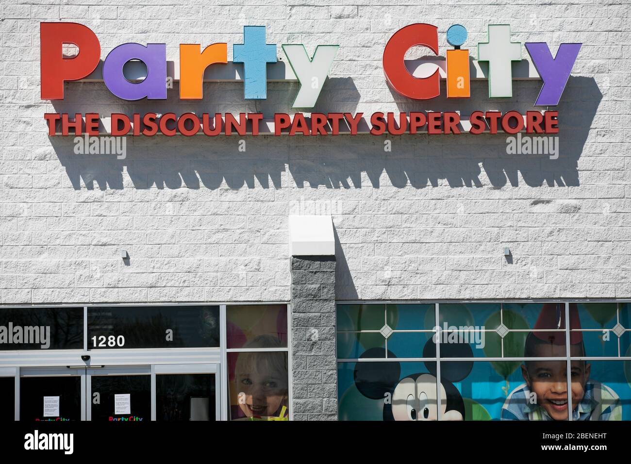 A logo sign outside of a Party City retail store location in