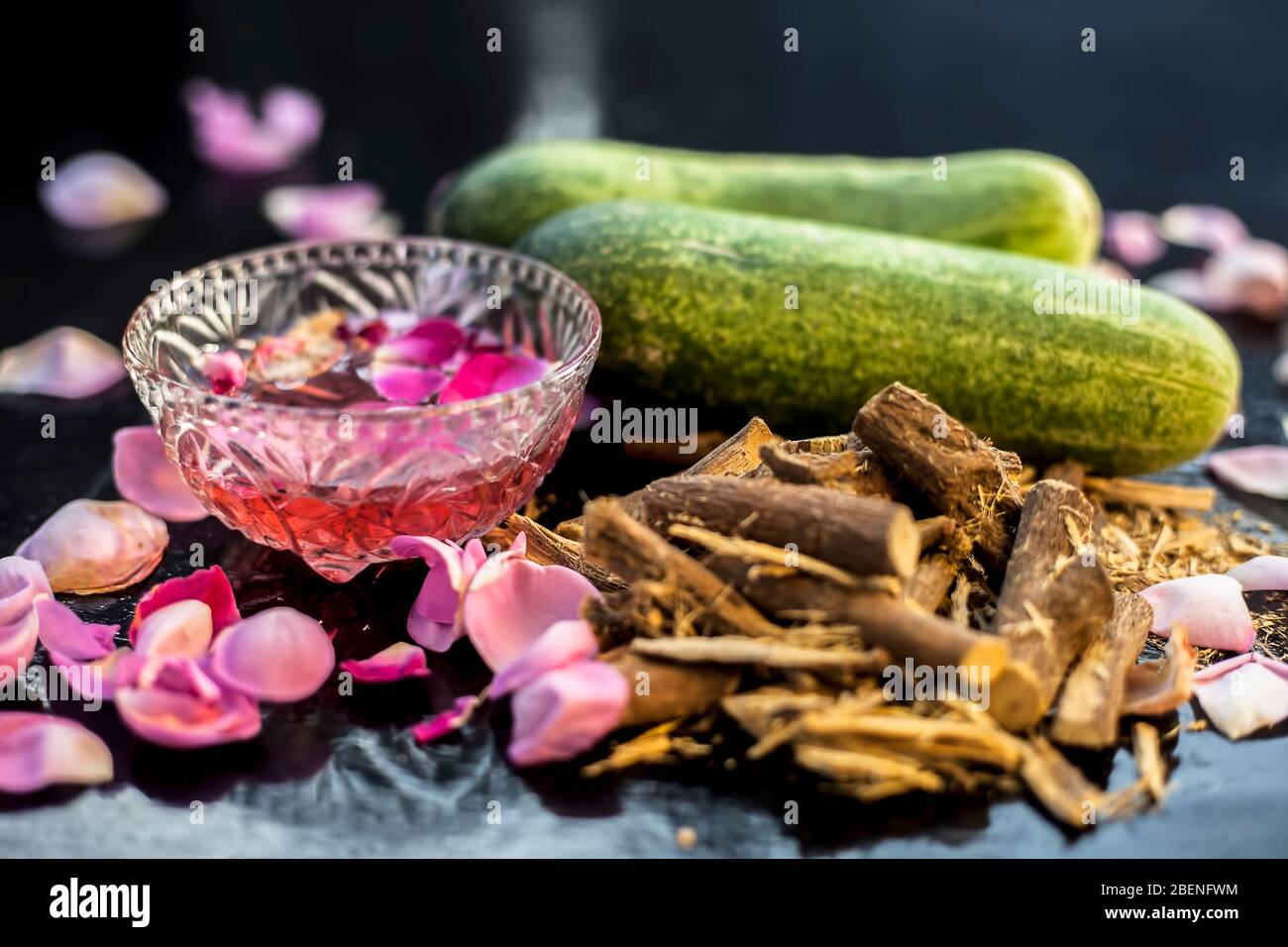 Skin whitening DIY face mask on a black shiny surface consisting of  cucumber slices rose water and some mulethi or licorice powder. Shot of rose  water Stock Photo - Alamy