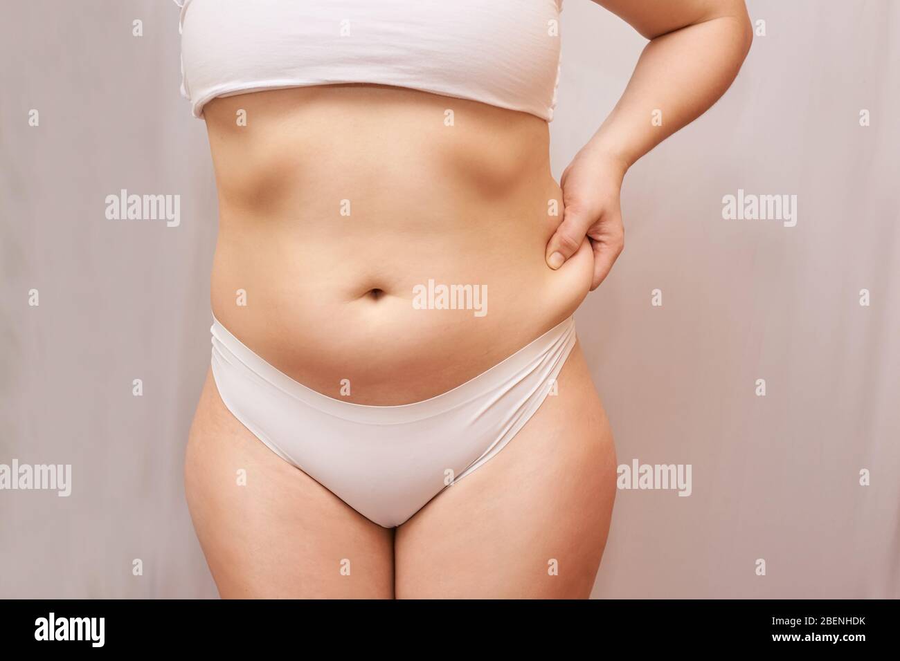 Fat unhealthy woman body. Pinch belly side. Measurement Stock Photo