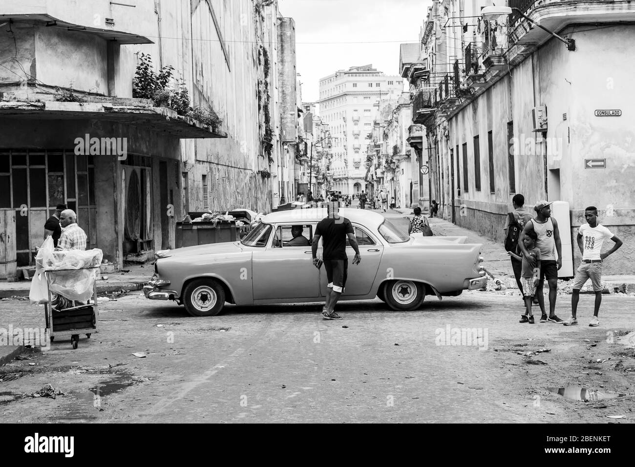 Looking over Calle Consulado in Cento Havana, Cuba as a classical car passes some locals on the streets.  Captured in November 2015. Stock Photo