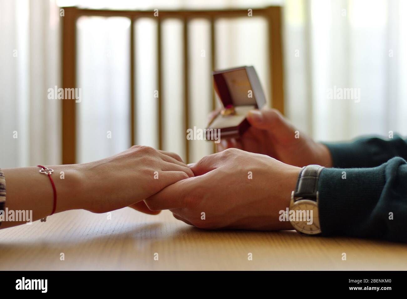 Closeup of man holding engagement ring and woman's hand Stock Photo