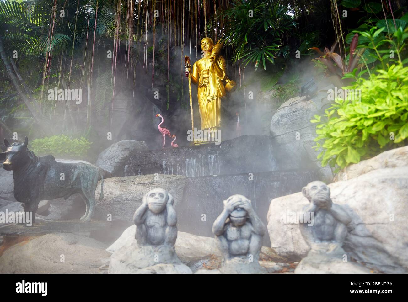 Golden Buddha statue in the tropical garden with waterfall in Wat Saket Golden Mountain Temple in Bangkok Stock Photo