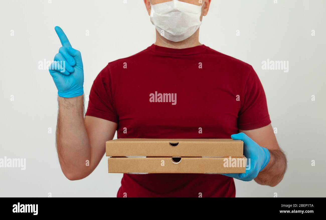 https://c8.alamy.com/comp/2BEP1TA/a-courier-in-medical-gloves-and-mask-holds-pizza-boxes-pizza-delivery-during-the-quarantine-contactless-delivery-2BEP1TA.jpg