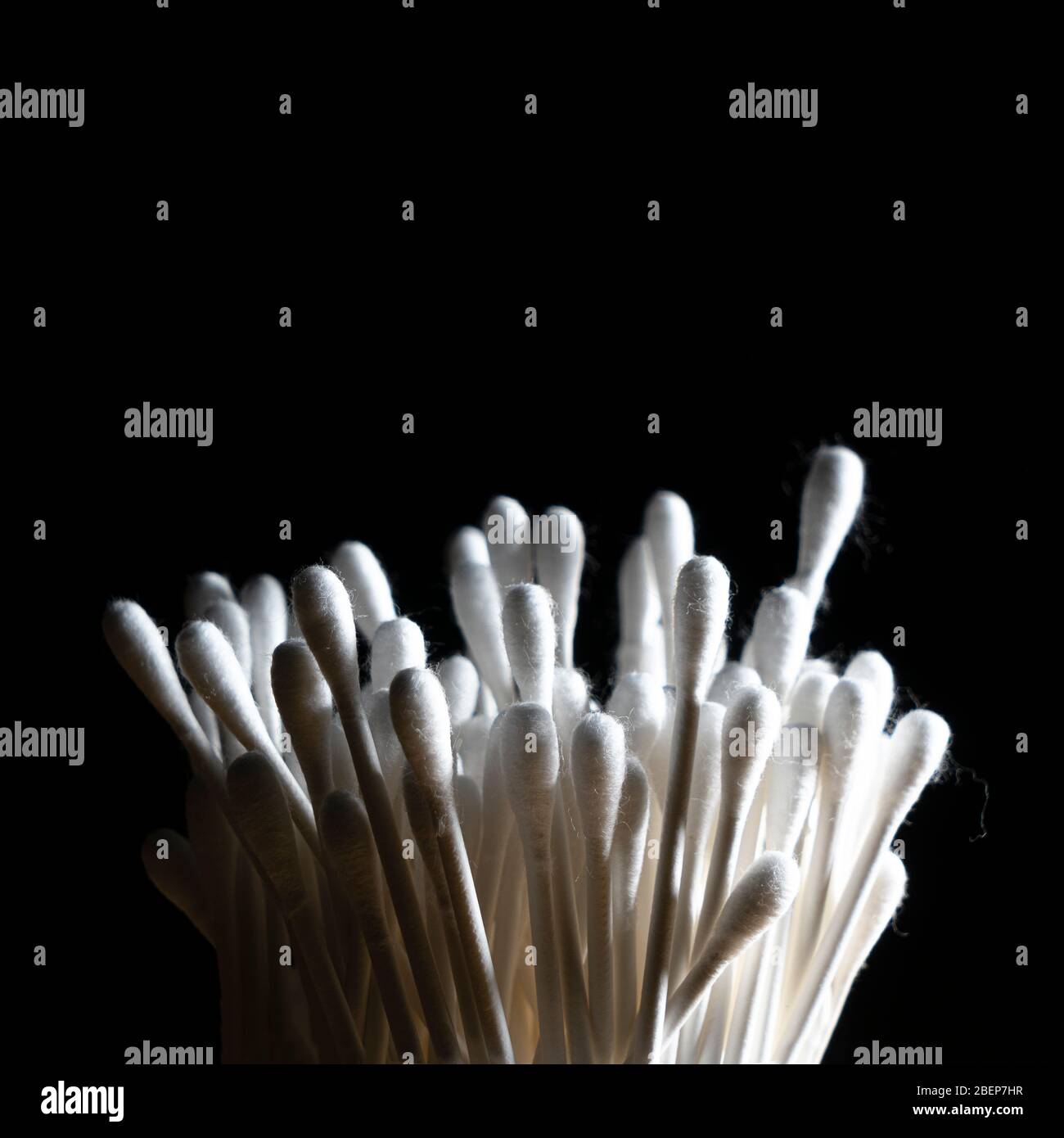 container of cotton buds in backlight on a black background Stock Photo