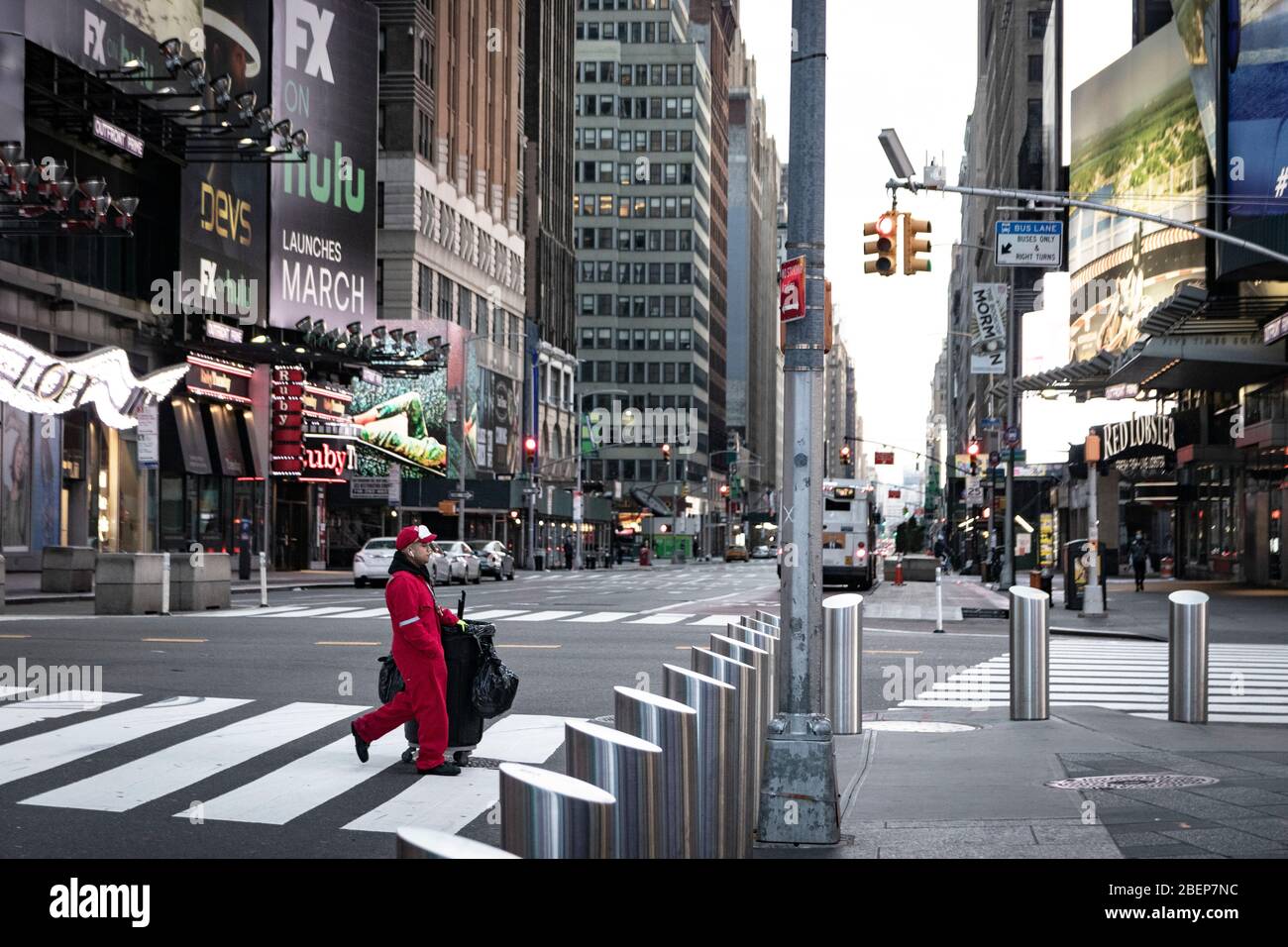 Sanitation worker in Times Square area streets, empty & void; theaters/restaurants/businesses have been shut down to prevent the spread of COVID-19. Stock Photo