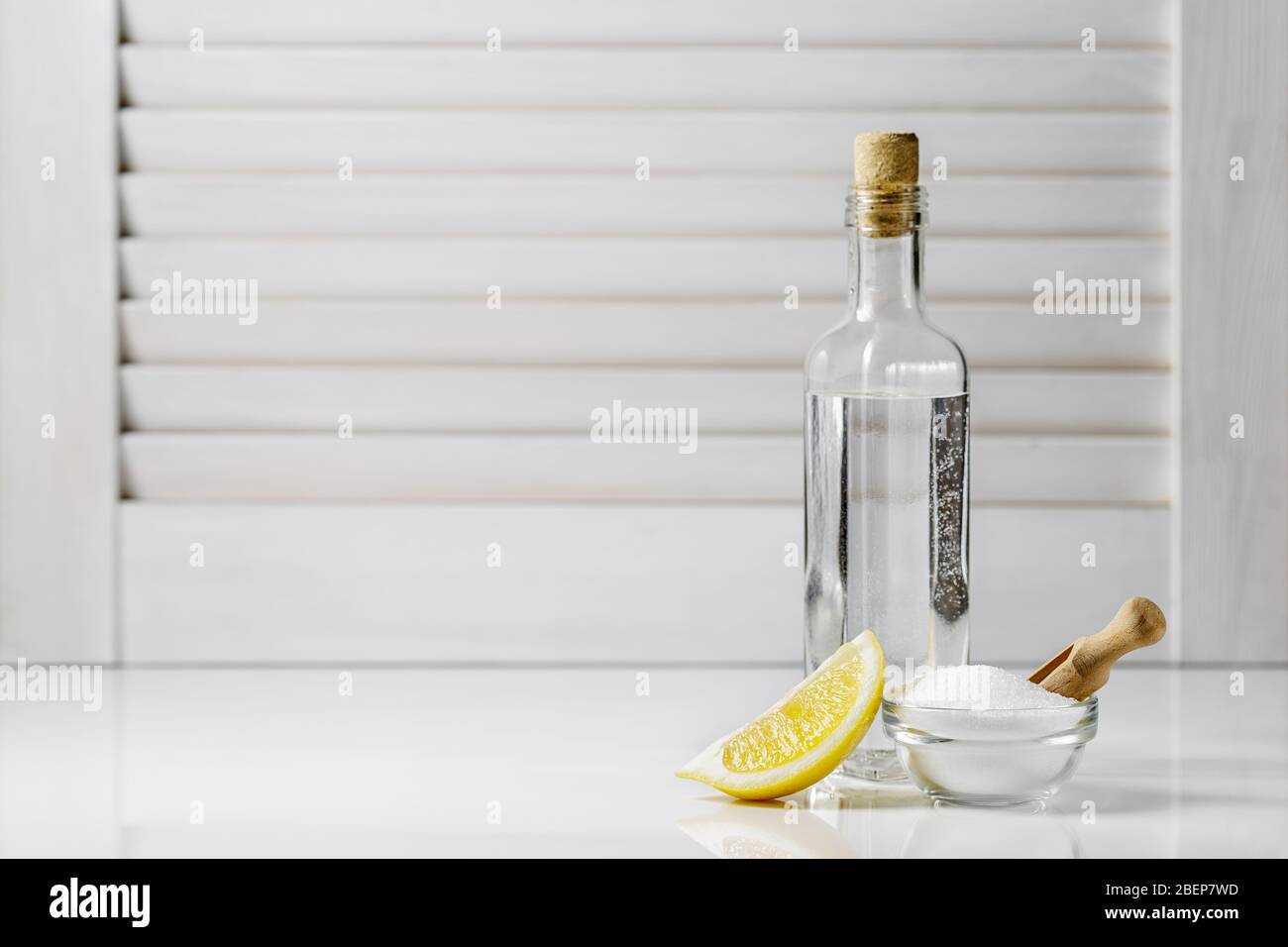 Citric acid in a small glass bowl, white vinegar in a bottle and a