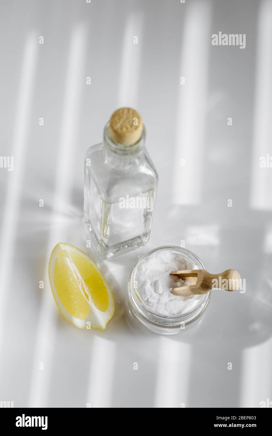 White vinegar, baking soda and lemon on the bright background. Eco friendly ingredients for