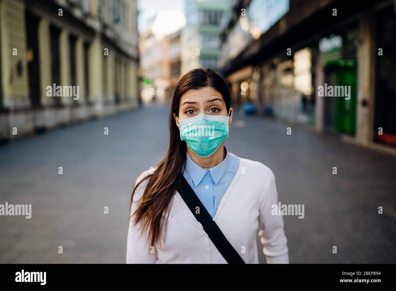 Anxious young adult affected by the COVID-19.Walking,going to work during pandemic.Protective measures,mask wearing and social distancing.Respecting g Stock Photo