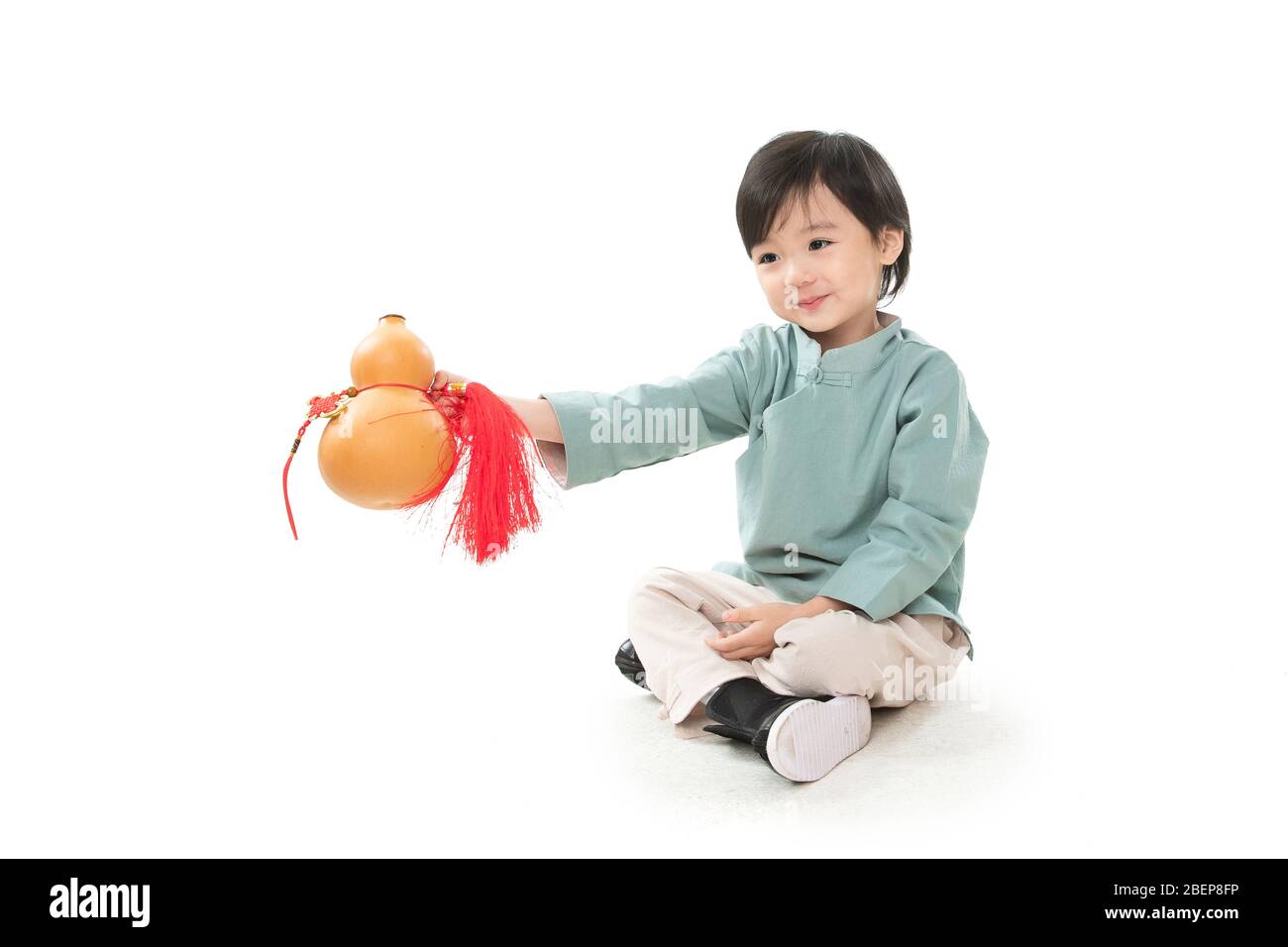 The little boy with a gourd sat crosslegged on the ground Stock Photo