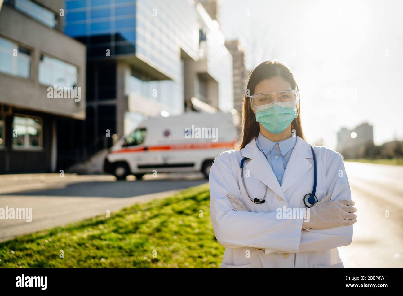 Brave coronavirus paramedic in front of isolation hospital facility.Covid-19 emergency room doctor with protective glasses / mask performing triage fo Stock Photo