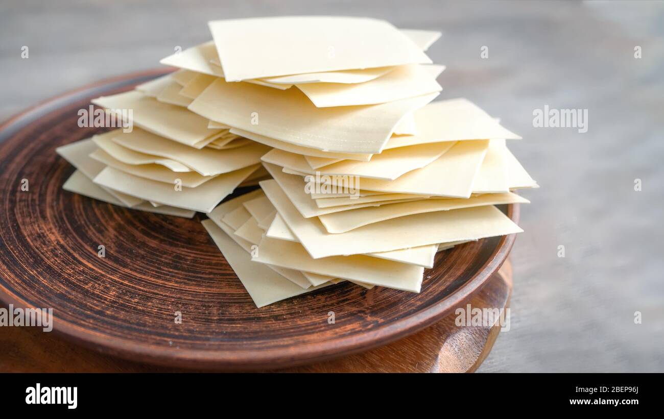 Ready-made dried dough squares for lasagna and beshbarmak. Sheets and thin layers of dough for national dishes. Copy space Stock Photo