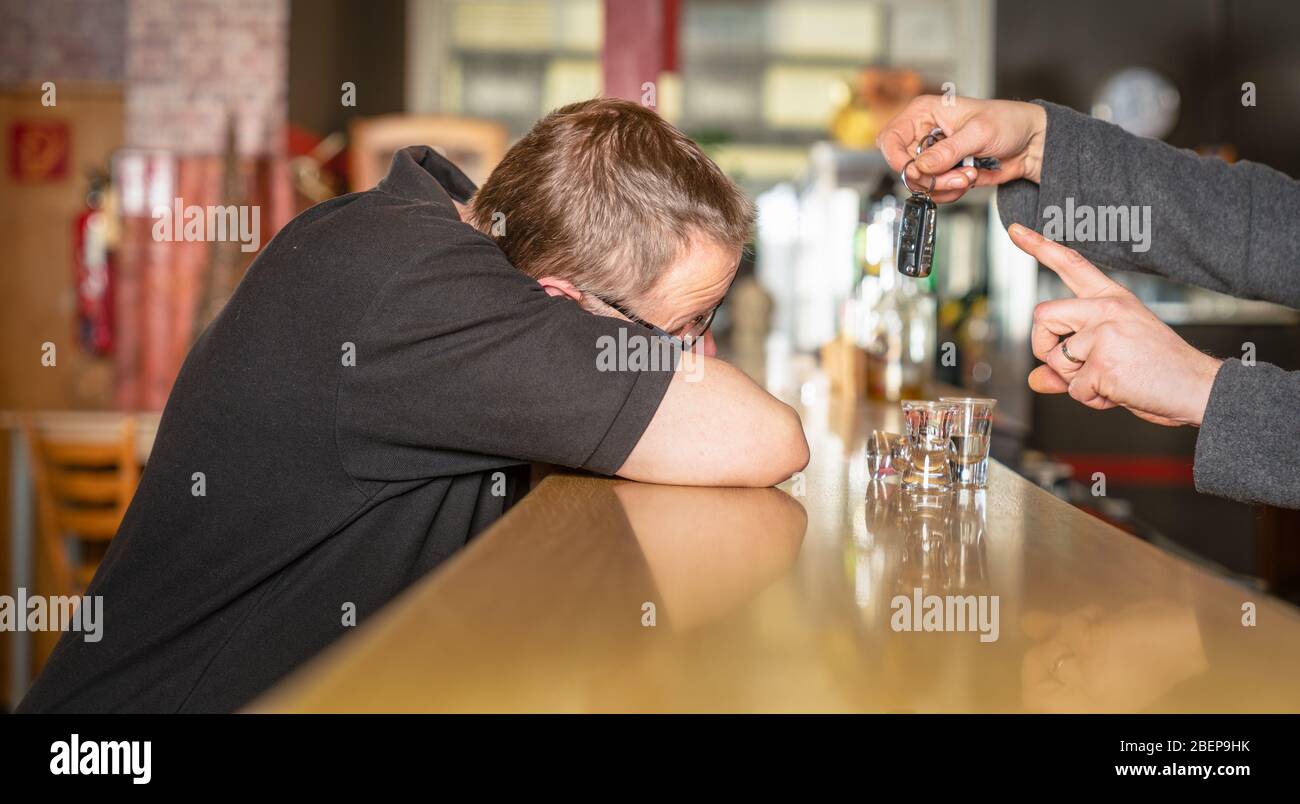 A publican prohibits a drunk guest from driving a car Stock Photo