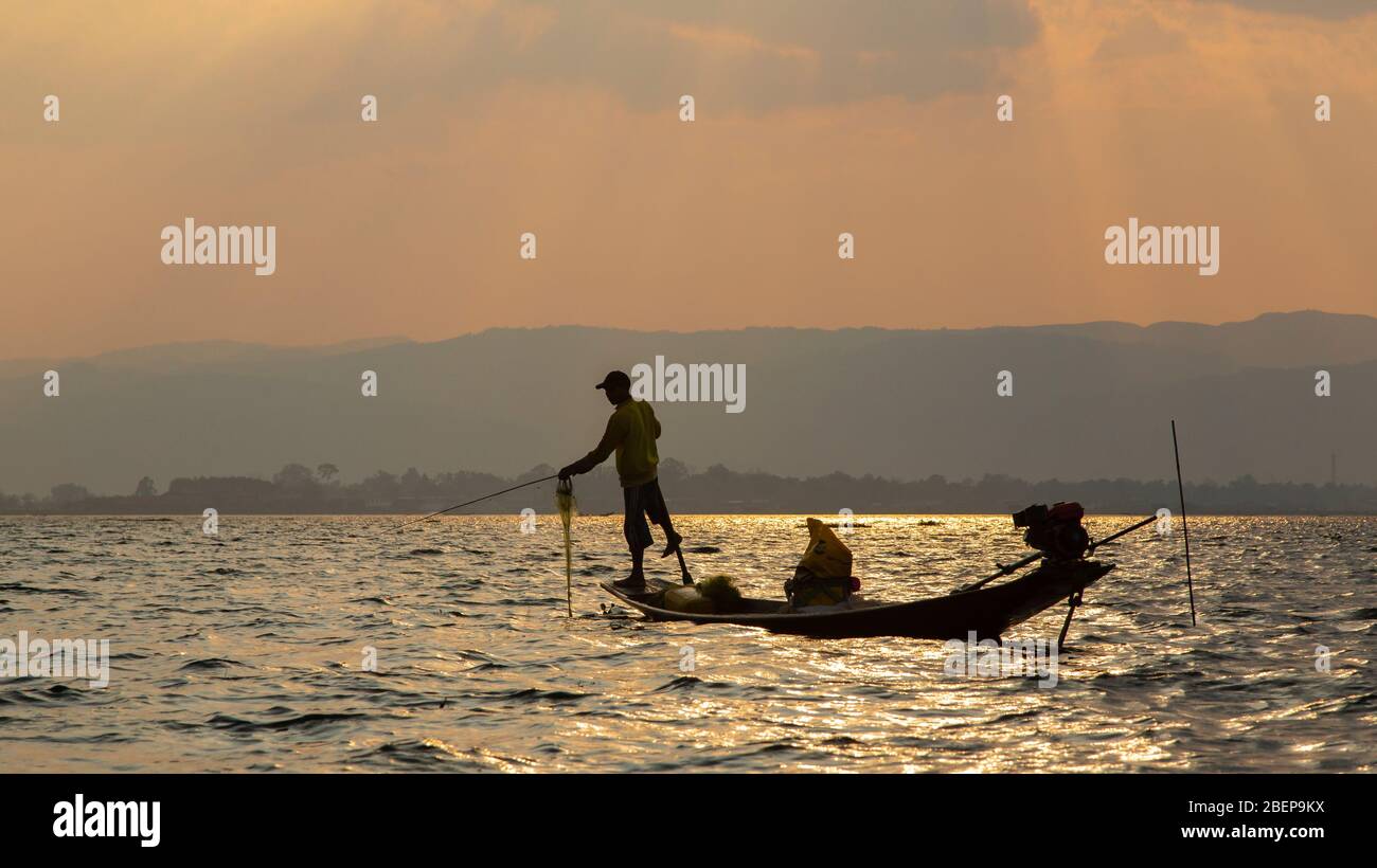 Silhouette of an Intha fisherman in the early morning on Inle lake, Myanmar Stock Photo