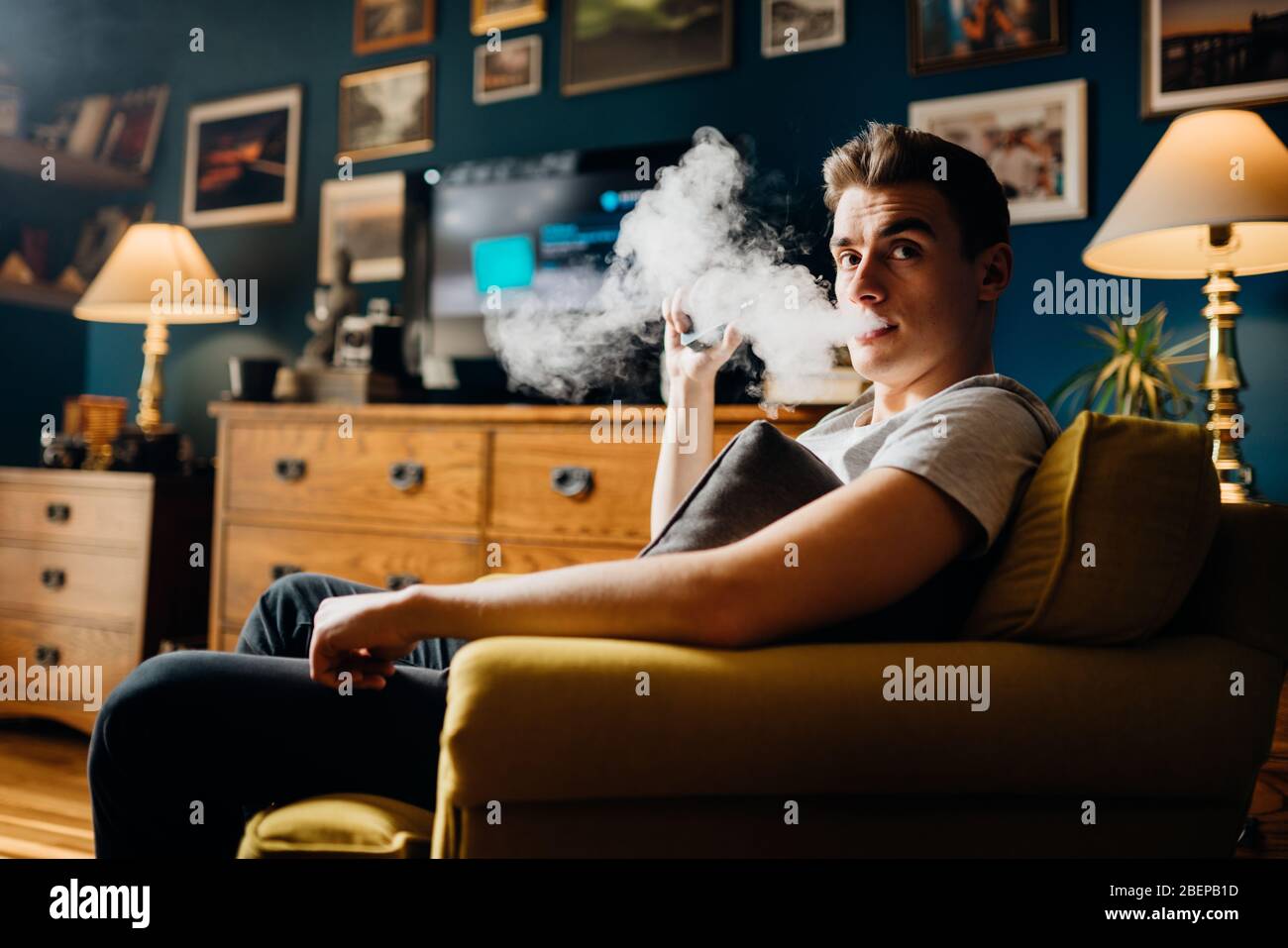 Exhaling the vapor with electronic cigarette.Puffing clouds of smoke.Vape flavor liquid chemicals.Use of e-cigarettes in the home.Smoking and vaping n Stock Photo