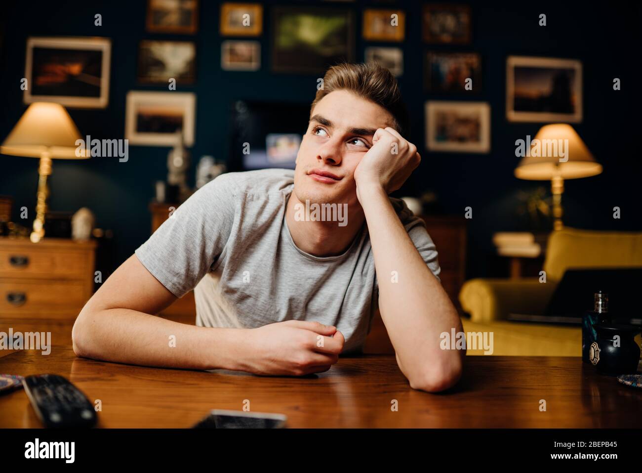 Thinking sad man in bad mood overthinking problems.Bored staying at home.Quarantine mental health effect.Self-isolation emotional challenge.Having an Stock Photo