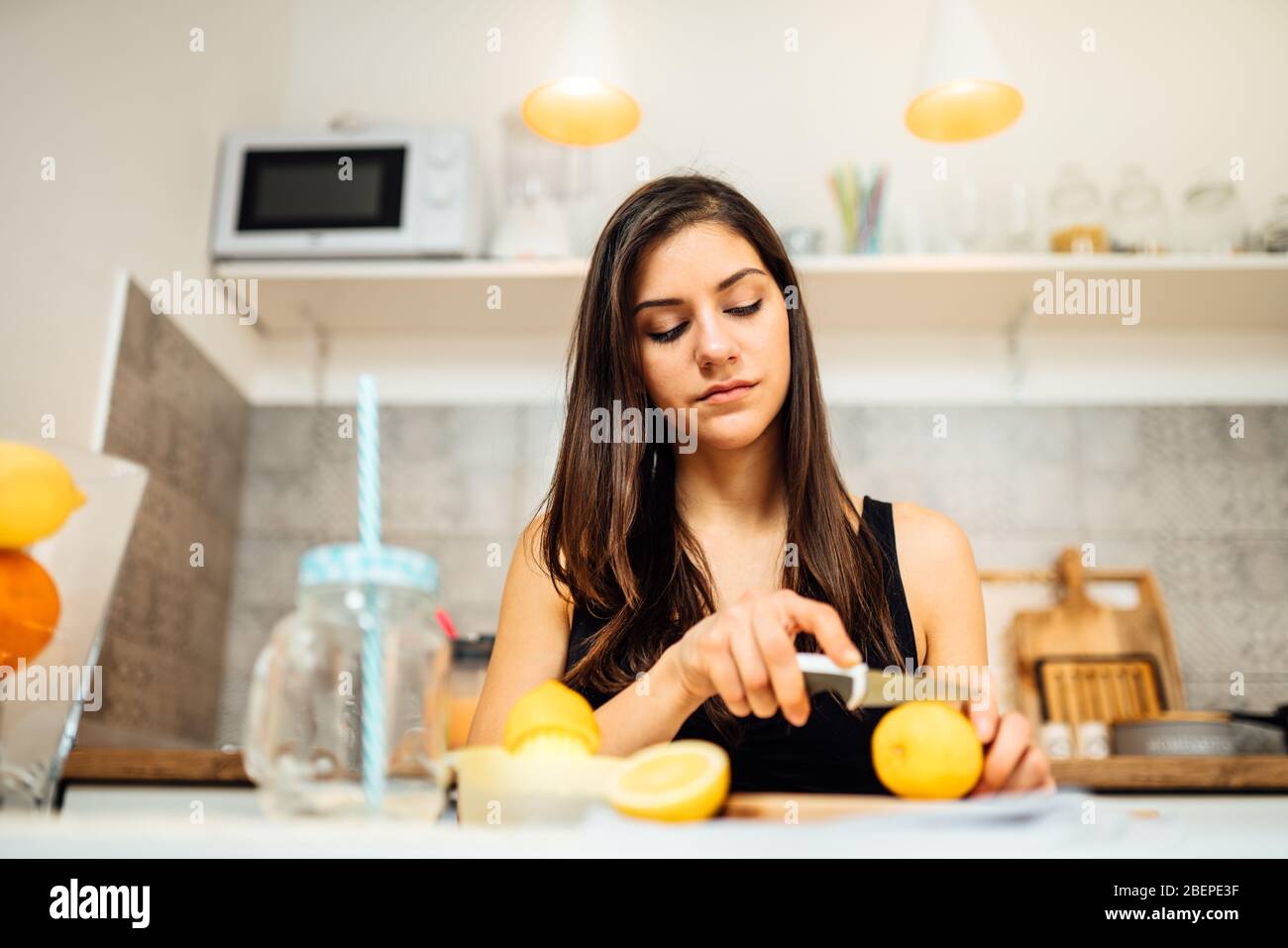 Healthy cheerful woman drinking homemade organic mixed citrus fruit  drink.Making lemonade.Detox diet,nutrition.Food for oily skin,strong immune  system Stock Photo - Alamy