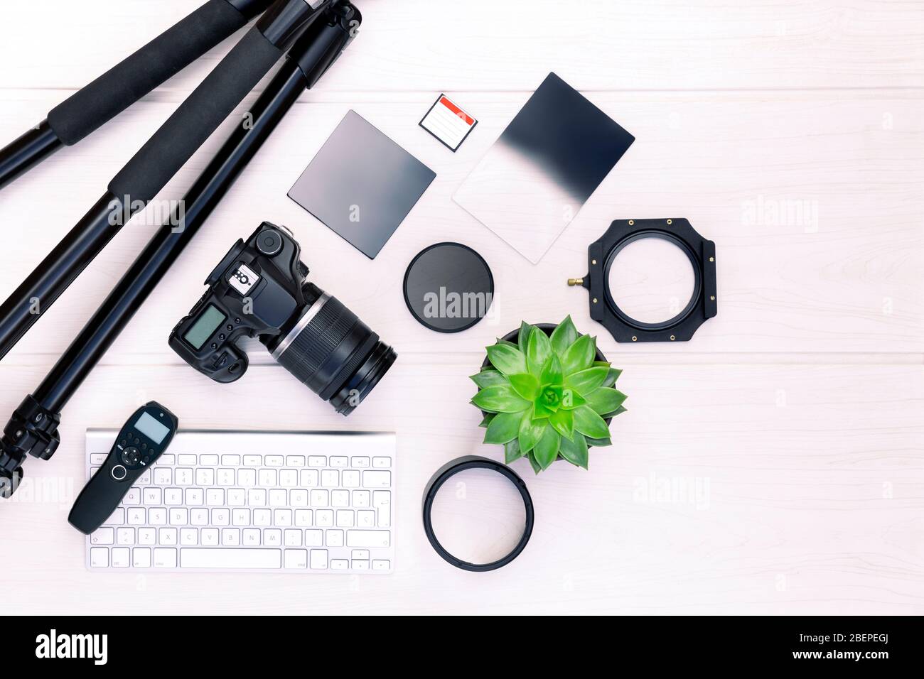 Top view of photographer workplace with dslr camera, lens and camera accessories on white wooden table with copy space for text. Photography concept. Stock Photo