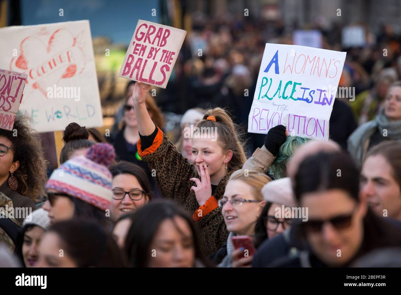 Portrait of female protester smoking and holding up a sign reading 'Grab 'Em By The Balls', at the 2017 Women's March, London Stock Photo