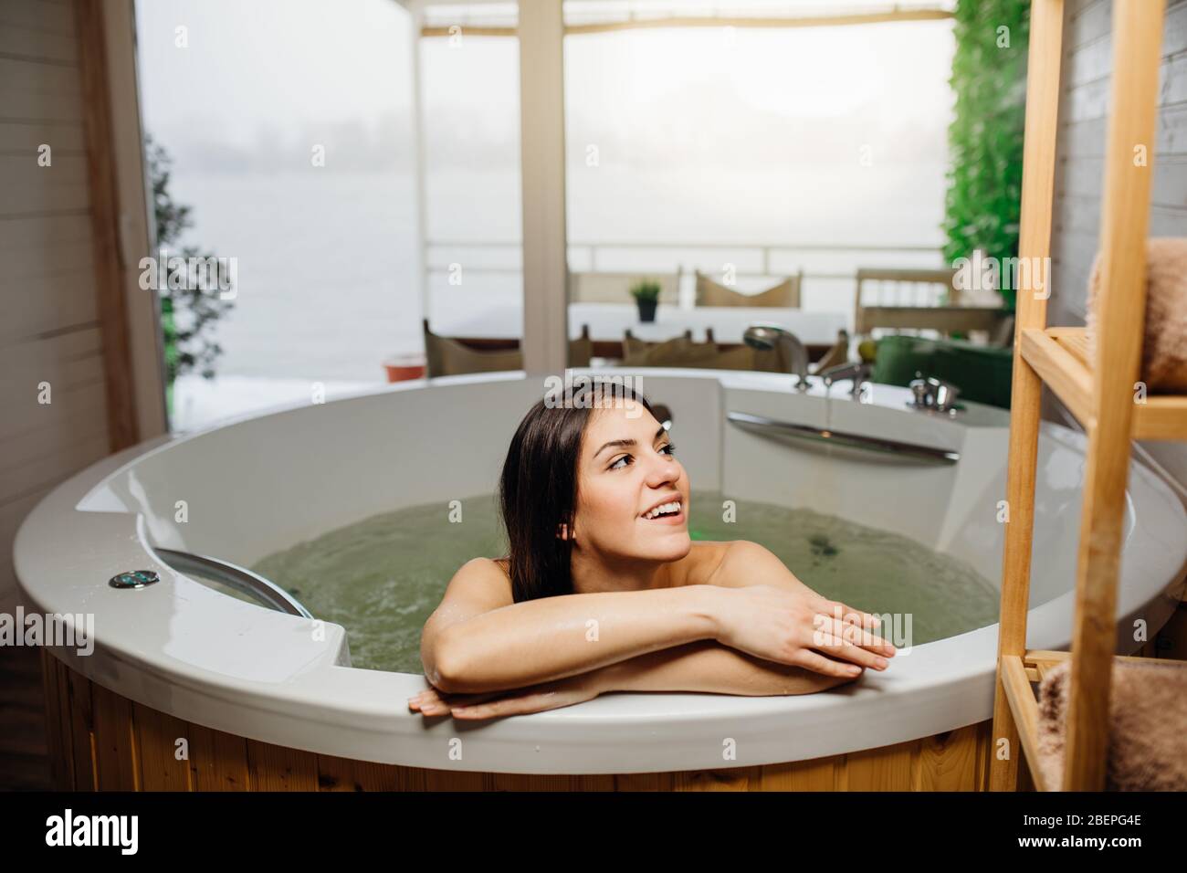 Woman having a spa day moment in modern bathroom indoors.Relaxing at ...