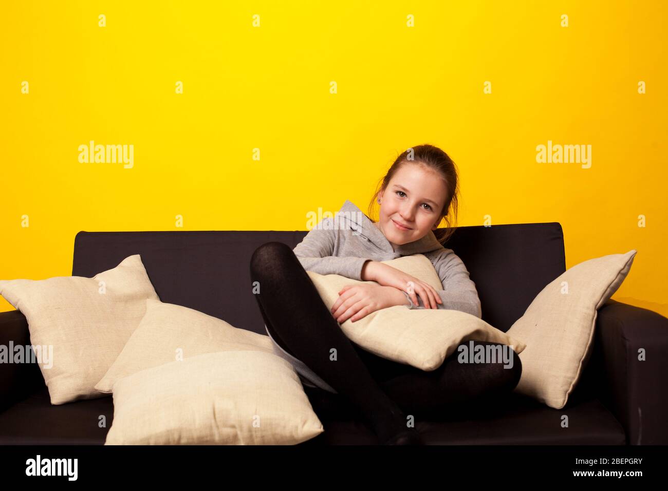 Beautiful little girl lies in a room on the couch Stock Photo - Alamy