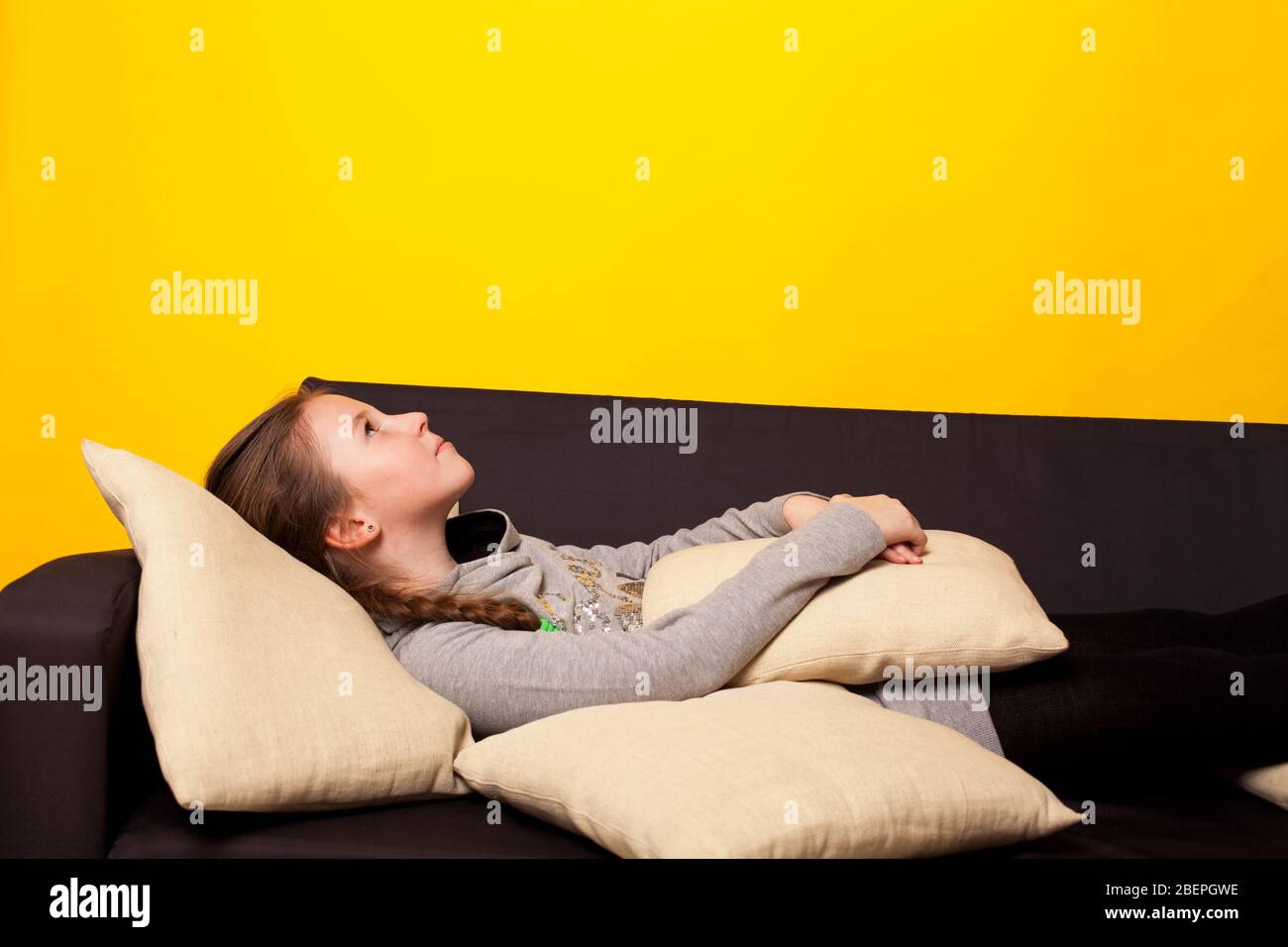 Beautiful little girl lies in a room on the couch Stock Photo - Alamy