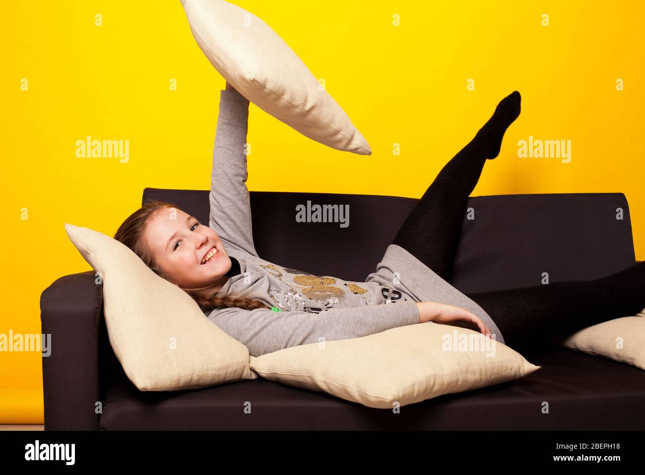 Beautiful little girl lies in a room on the couch Stock Photo - Alamy