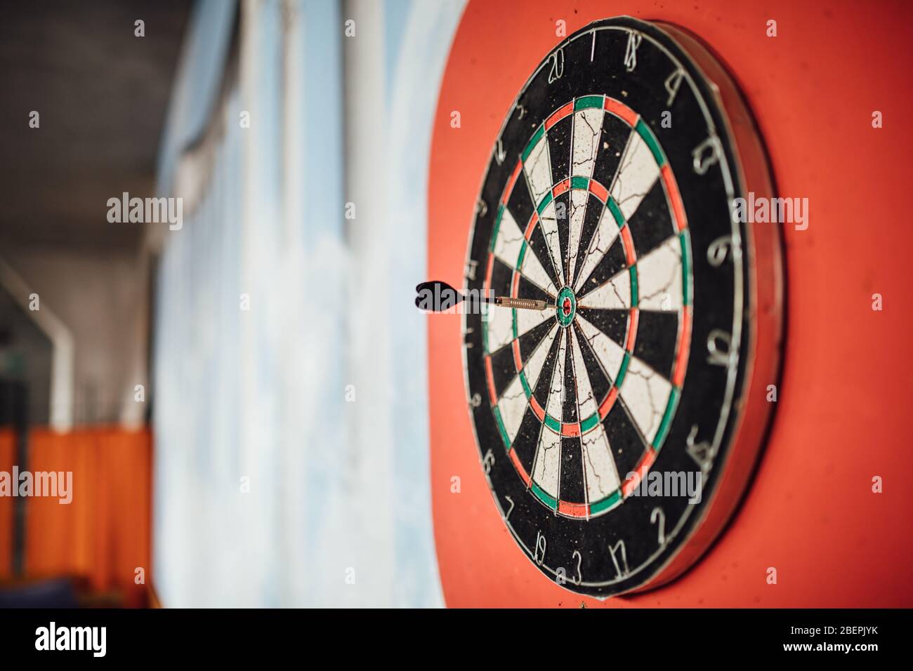 Dart arrow hitting in bulls eye on dartboard.Success hitting target aim goal achievement concept.Indoor game,played at home. Stock Photo