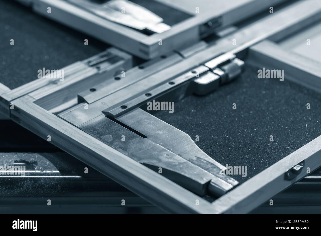 Steel calipers in cases are on a table, blue toned close-up photo with selective focus Stock Photo