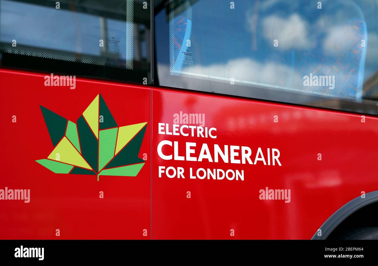 Emblem and wording - 'Electric cleaner air for London' - on the side of an electric bus in London. With fluffy white clouds reflected in the window. Stock Photo