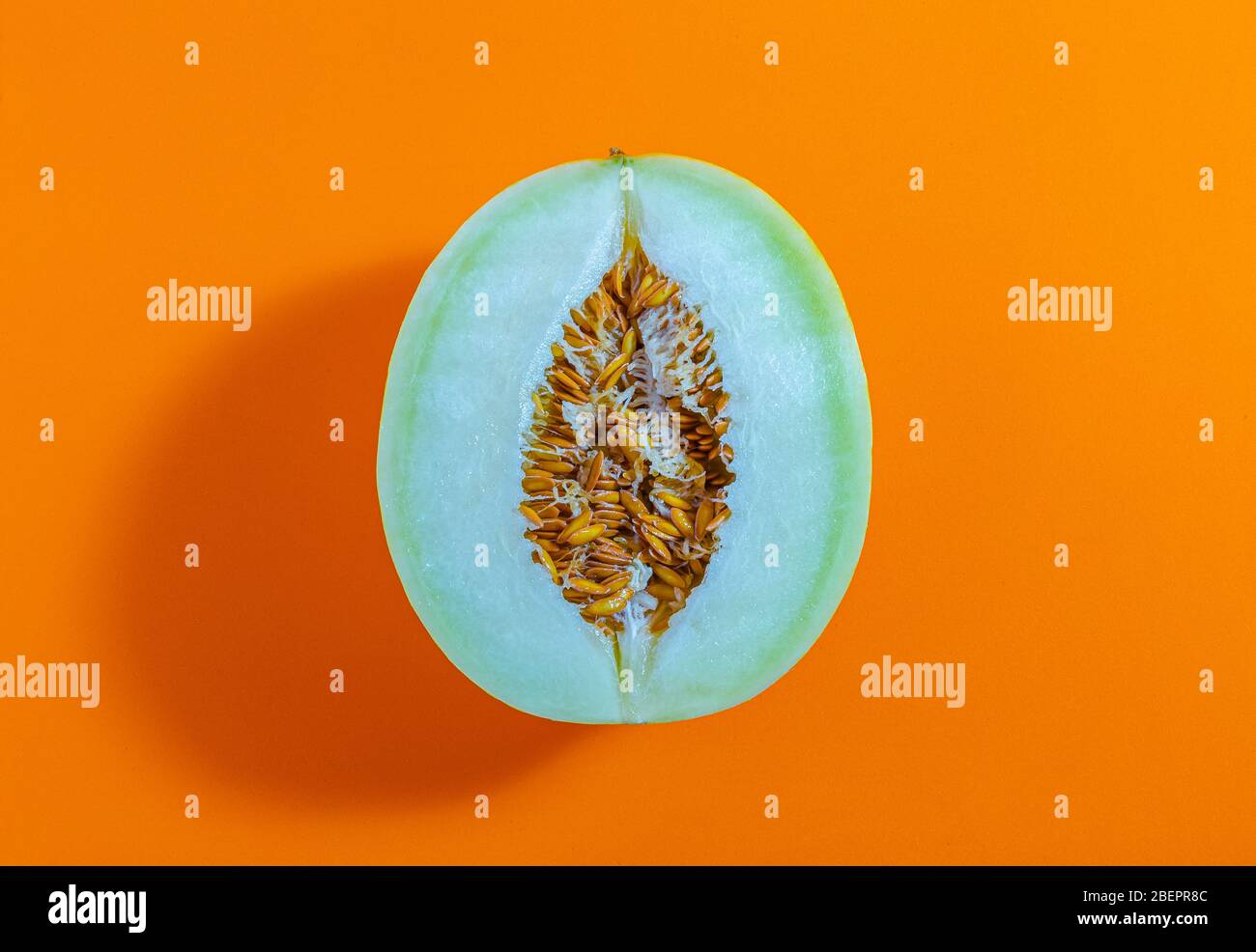 Fresh melon isolated on orange background, top view, concept photo. Stock Photo