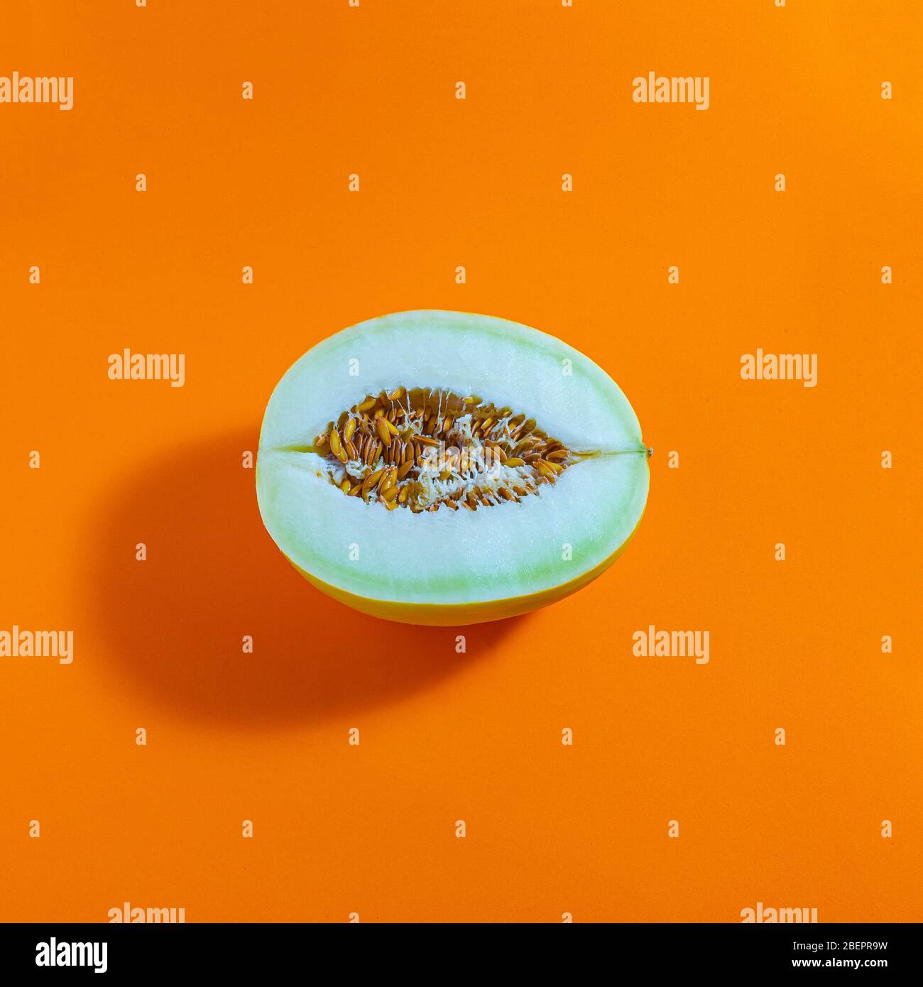 Fresh melon isolated on orange background, top view, concept photo. Stock Photo