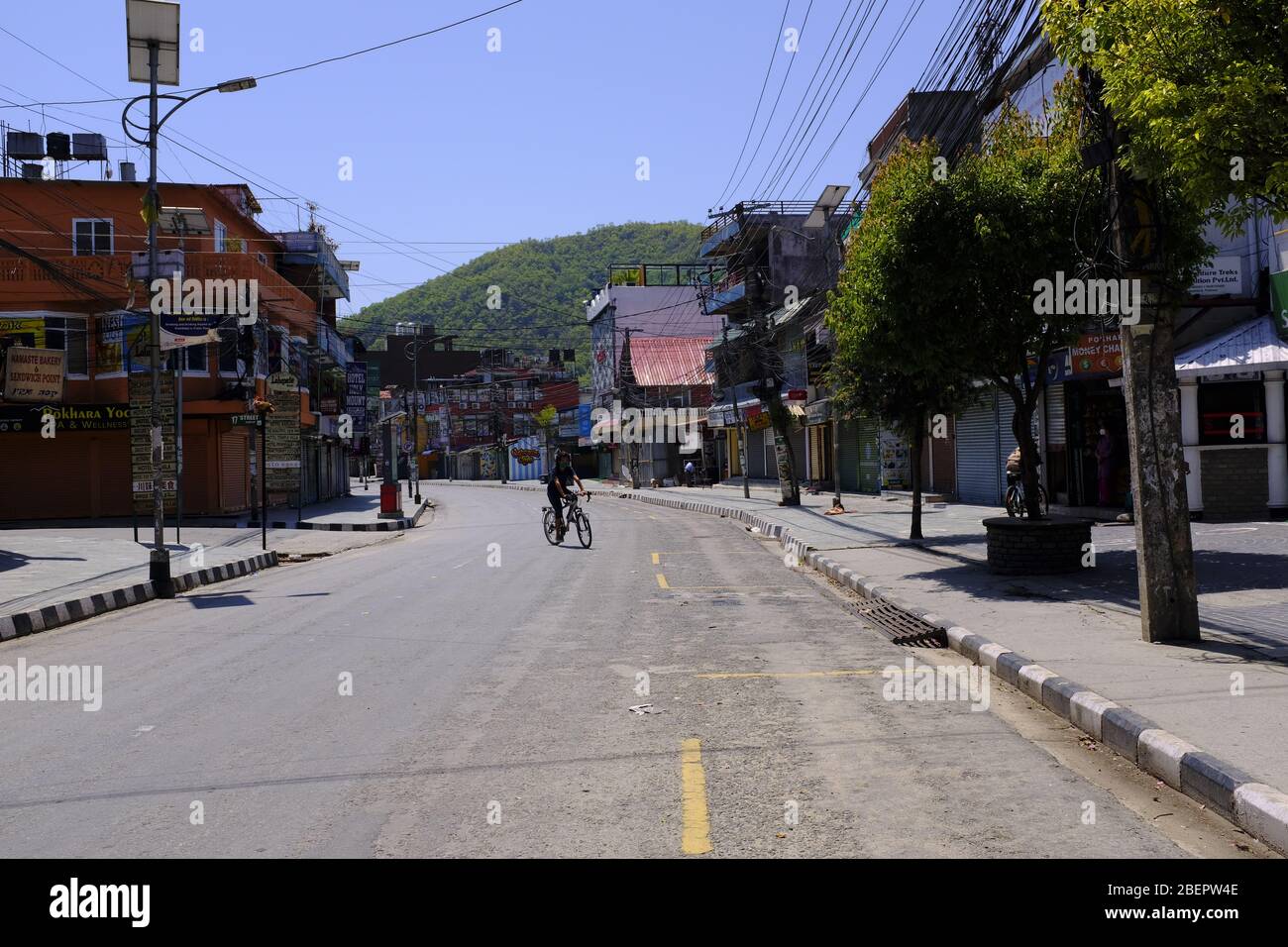A Nepali man riding a bicycle in empty street of Pokhara city, Nepal during lockdown Stock Photo