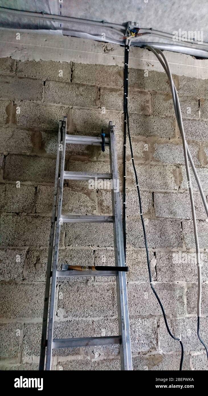 ladder ladder on the background of a cinder block wall Stock Photo - Alamy