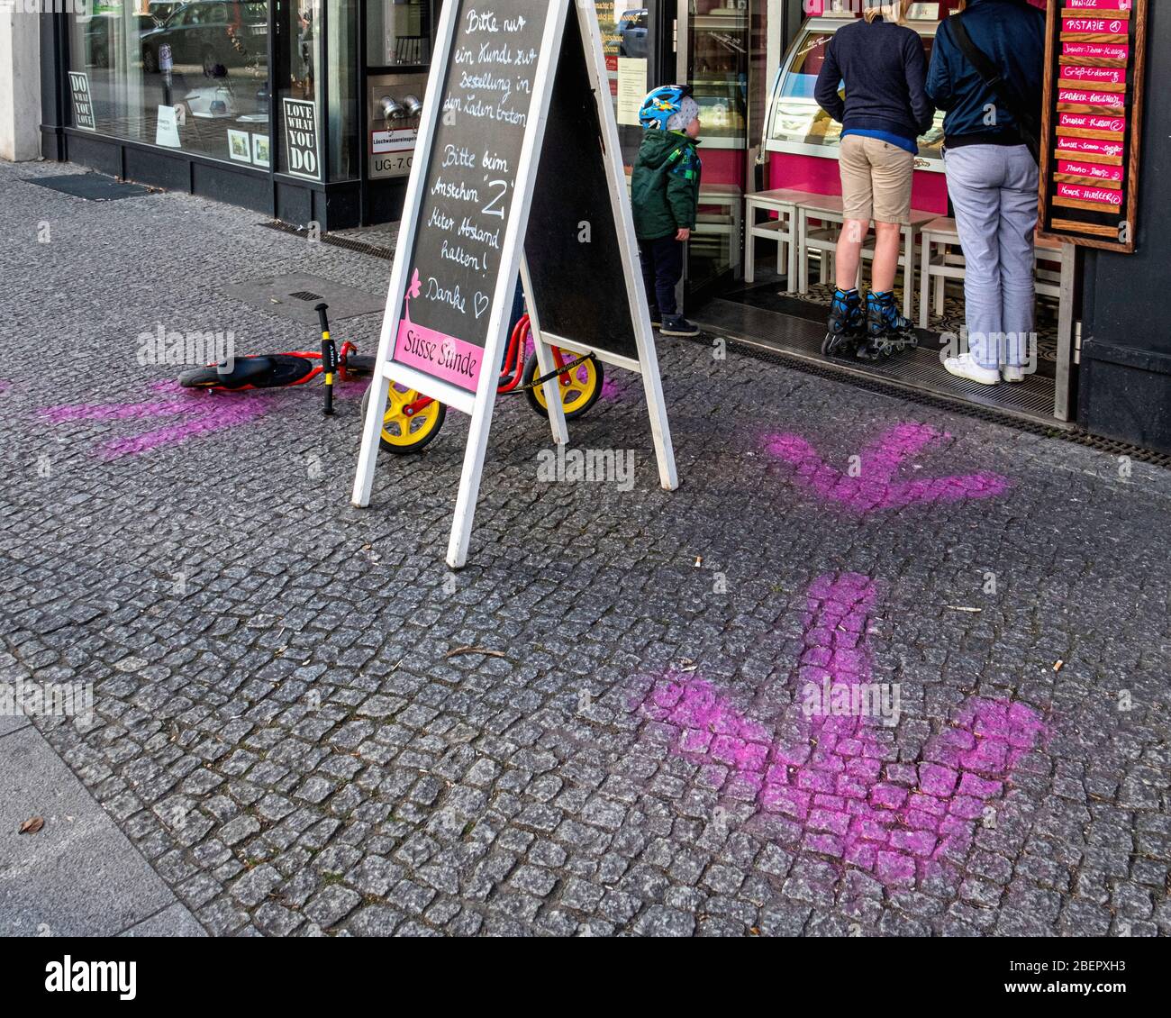 Berlin, Mitte, COVID-19 epidemic. Pavement markings give social dstancing outside  Süsse Sunde ice cream shop Stock Photo