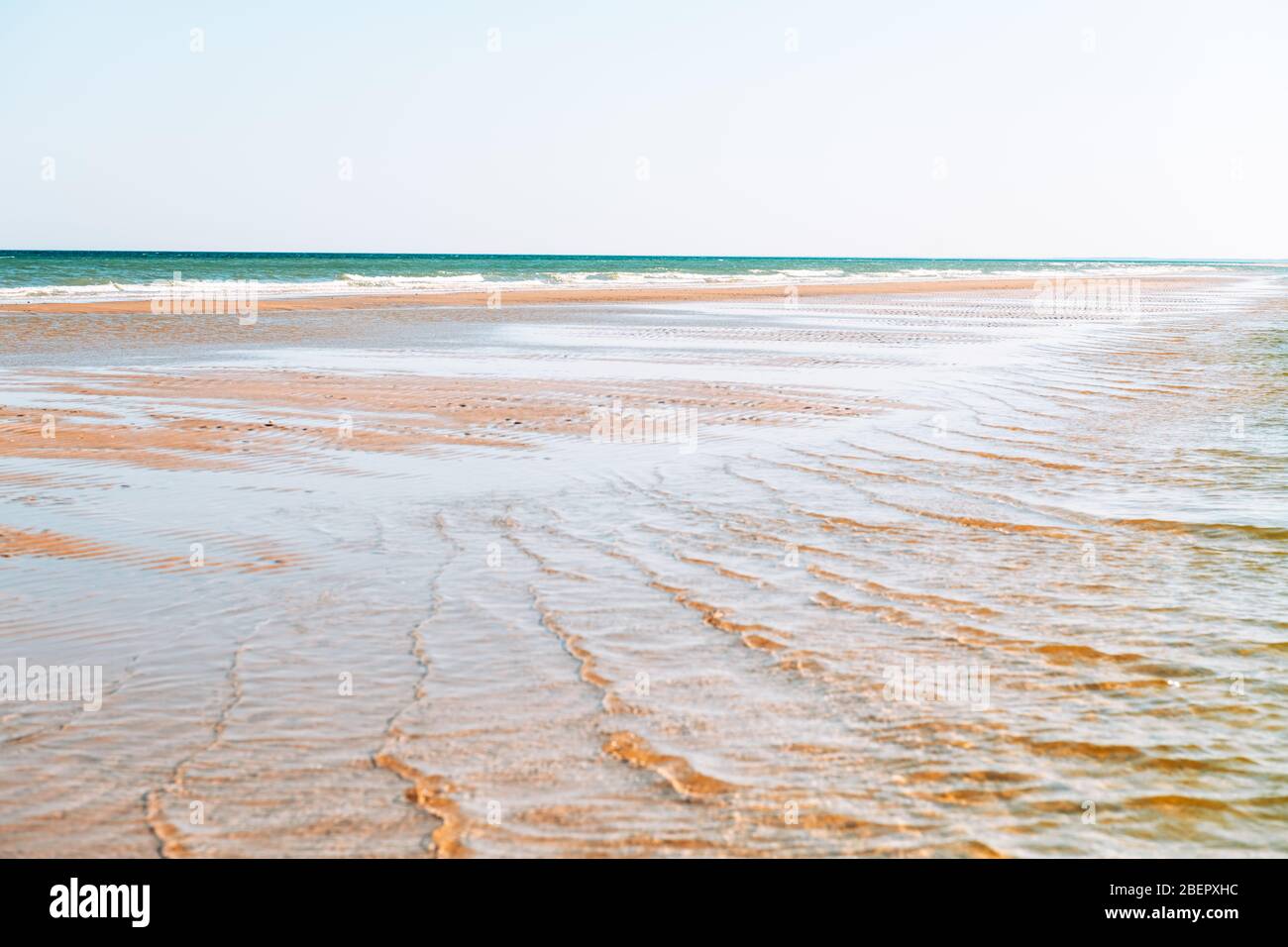 Tide waves on tropical beach sand and blue ocean water. Beauty sea texture. Vacations background Stock Photo