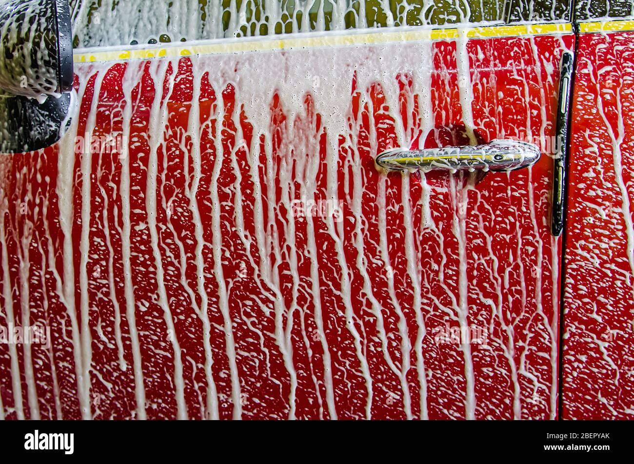 Cleaning red cars. Wash the car at the car wash station with foam