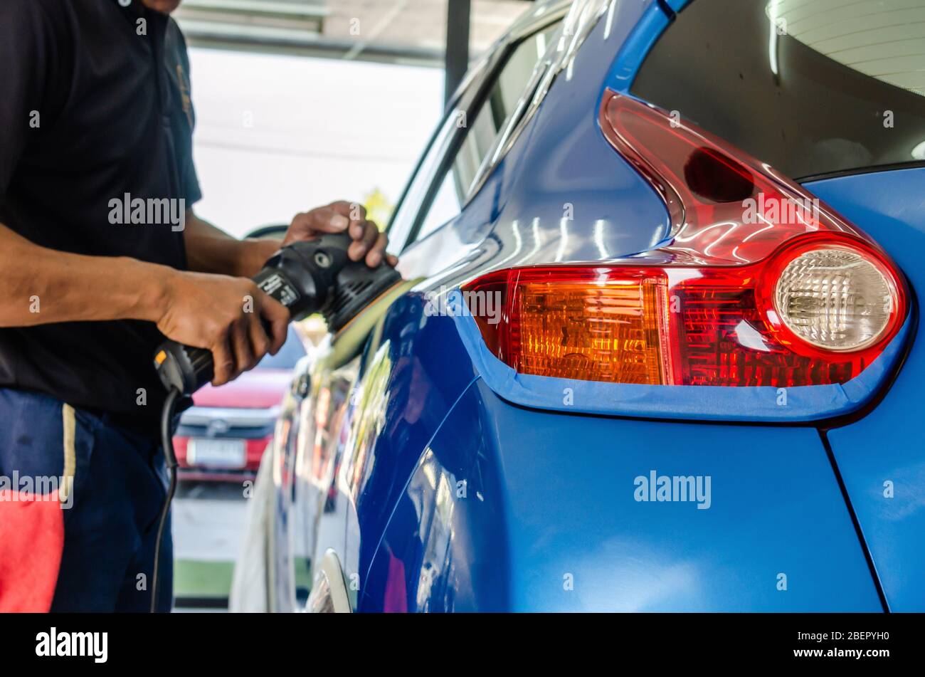 Auto polishing with machine.Blue car polish to remove and recover the car.Focus on car tail lights Stock Photo