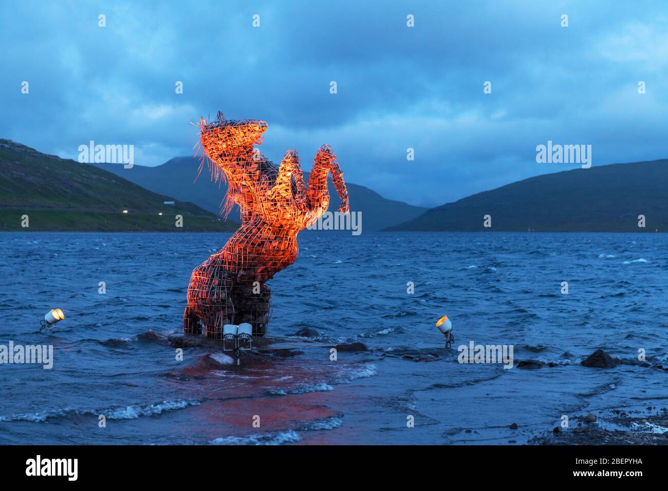 Incredible evening scene with luminous mythical horse Nykur Nix Statue in Sorvagsvatn lake waters near the airport in Vagar on the Faroe Islands, Denmark Stock Photo