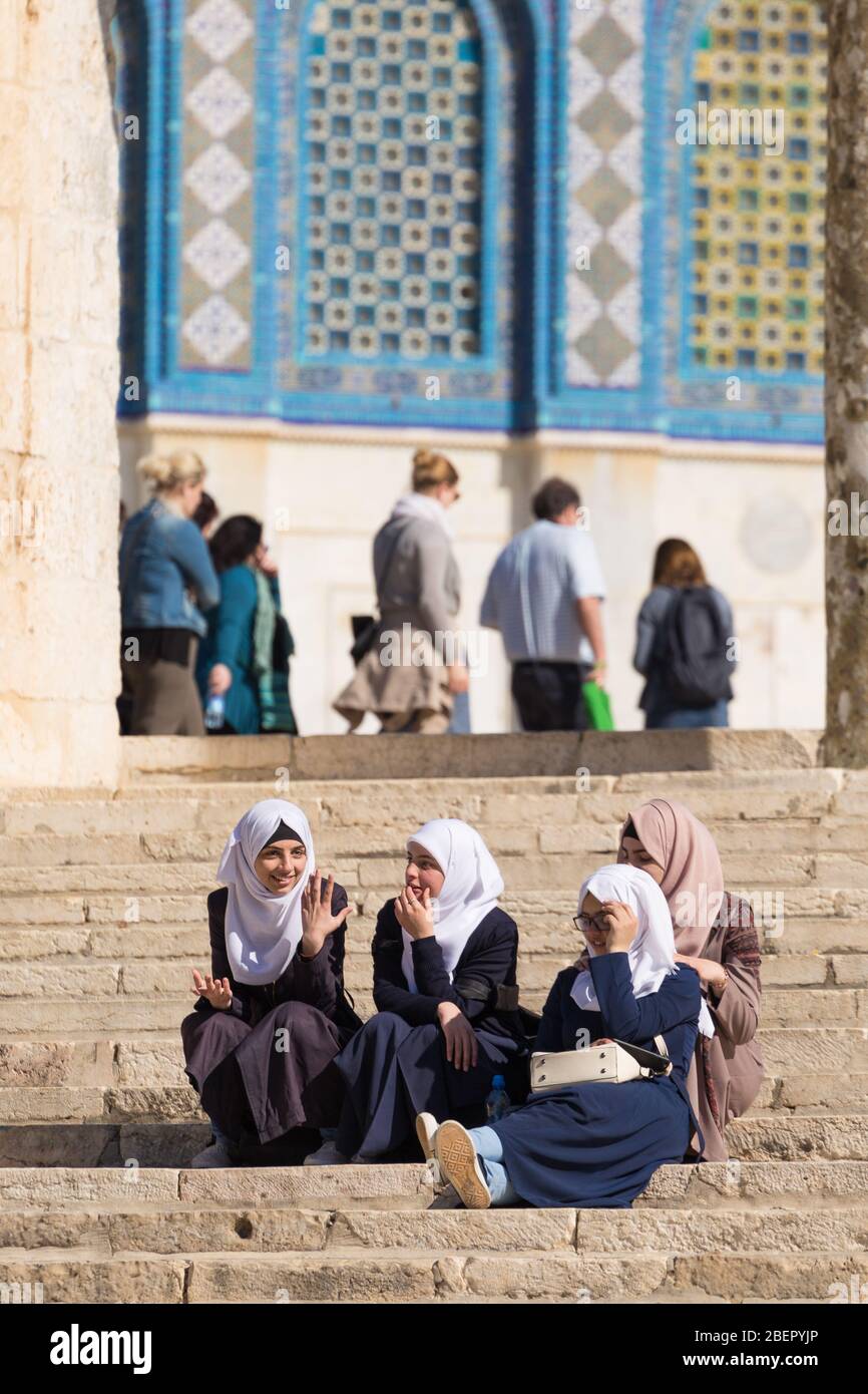 Four muslim girls sitting on steps at the Dome of the Rock in Jerusalem, Israel Stock Photo