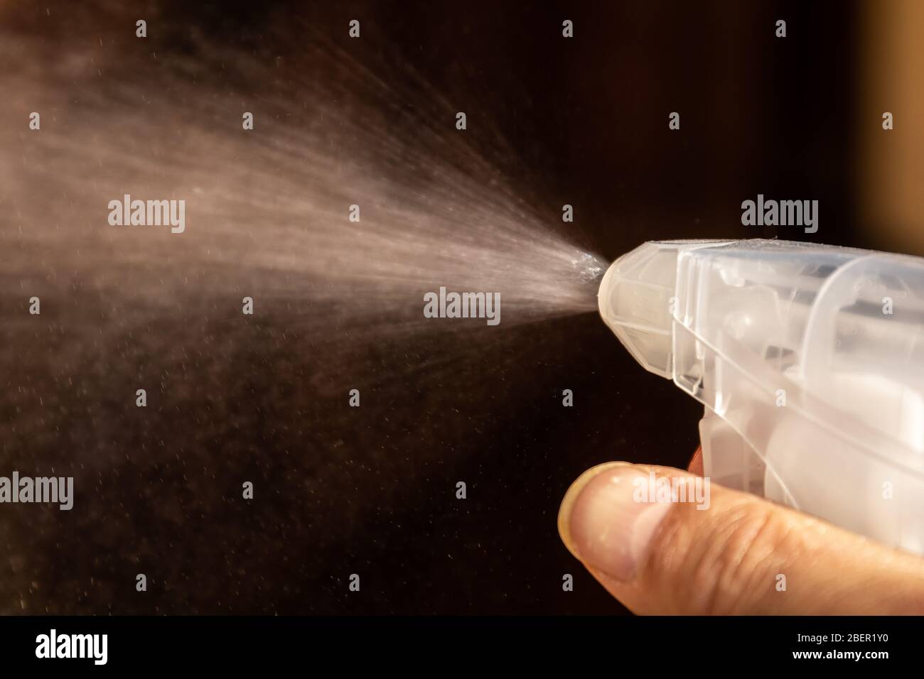 Plastic squirt bottle sprays liquid out of its nozzle Stock Photo