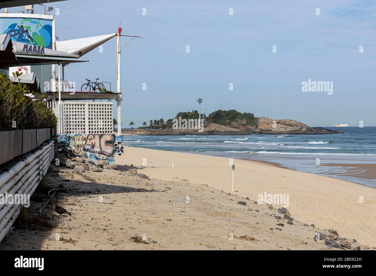 Empty beach with kiosk and lifeguard post with the Arpoador rock in the background during the COVID-19 Corona virus outbreak Stock Photo