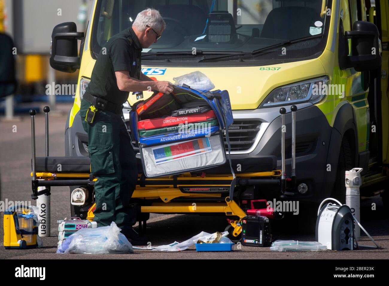 An NHS worker lays out breathing apparatus and equipment outside an ambulance outside the NHS Nightingale Hospital at the Excel Centre in London as the UK continues in lockdown to help curb the spread of the coronavirus. Stock Photo