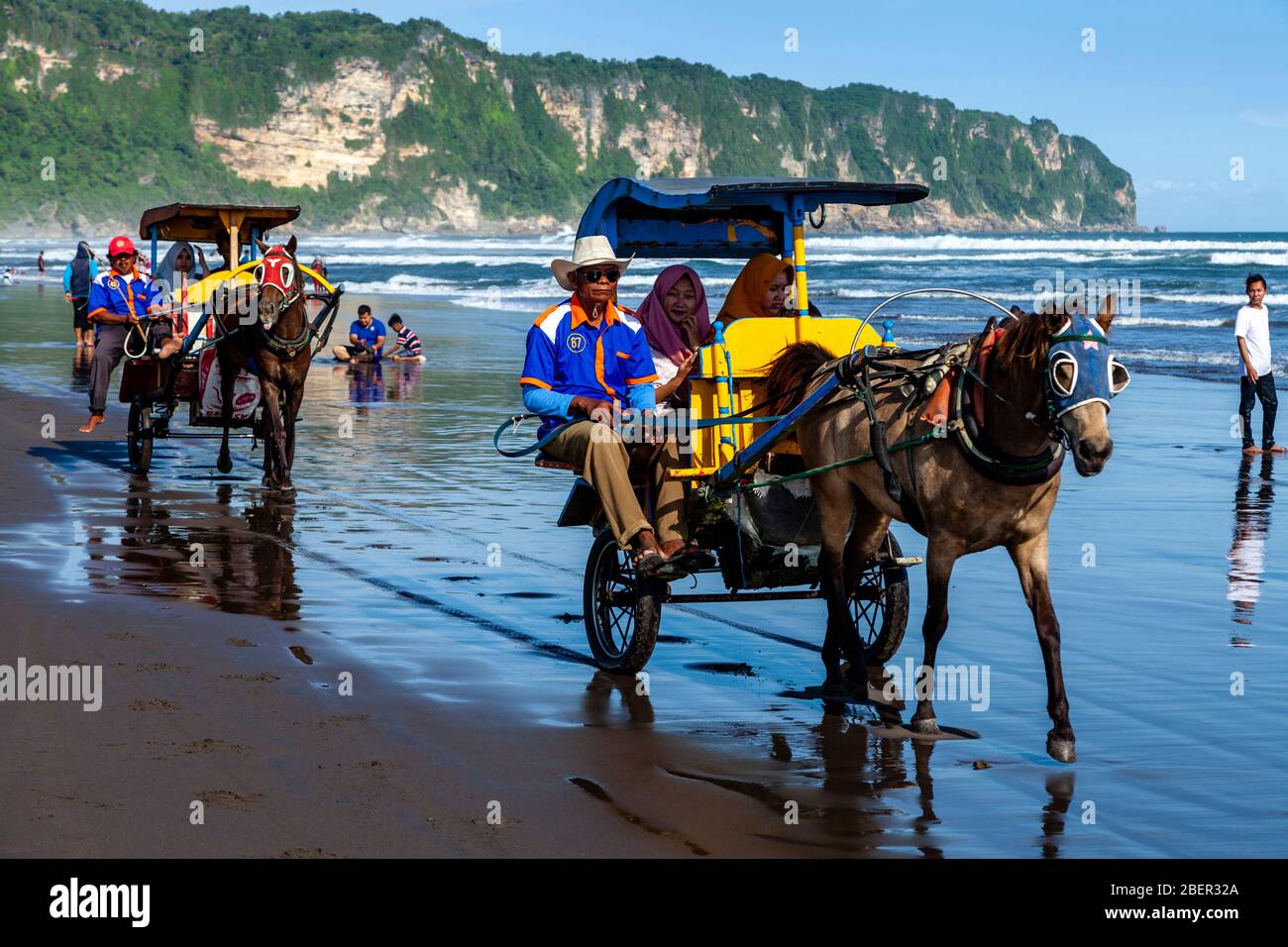 Indonesian People Enjoying Horse and Carriage Rides On Parangtritis Beach, Yogyakarta, Indonesia. Stock Photo