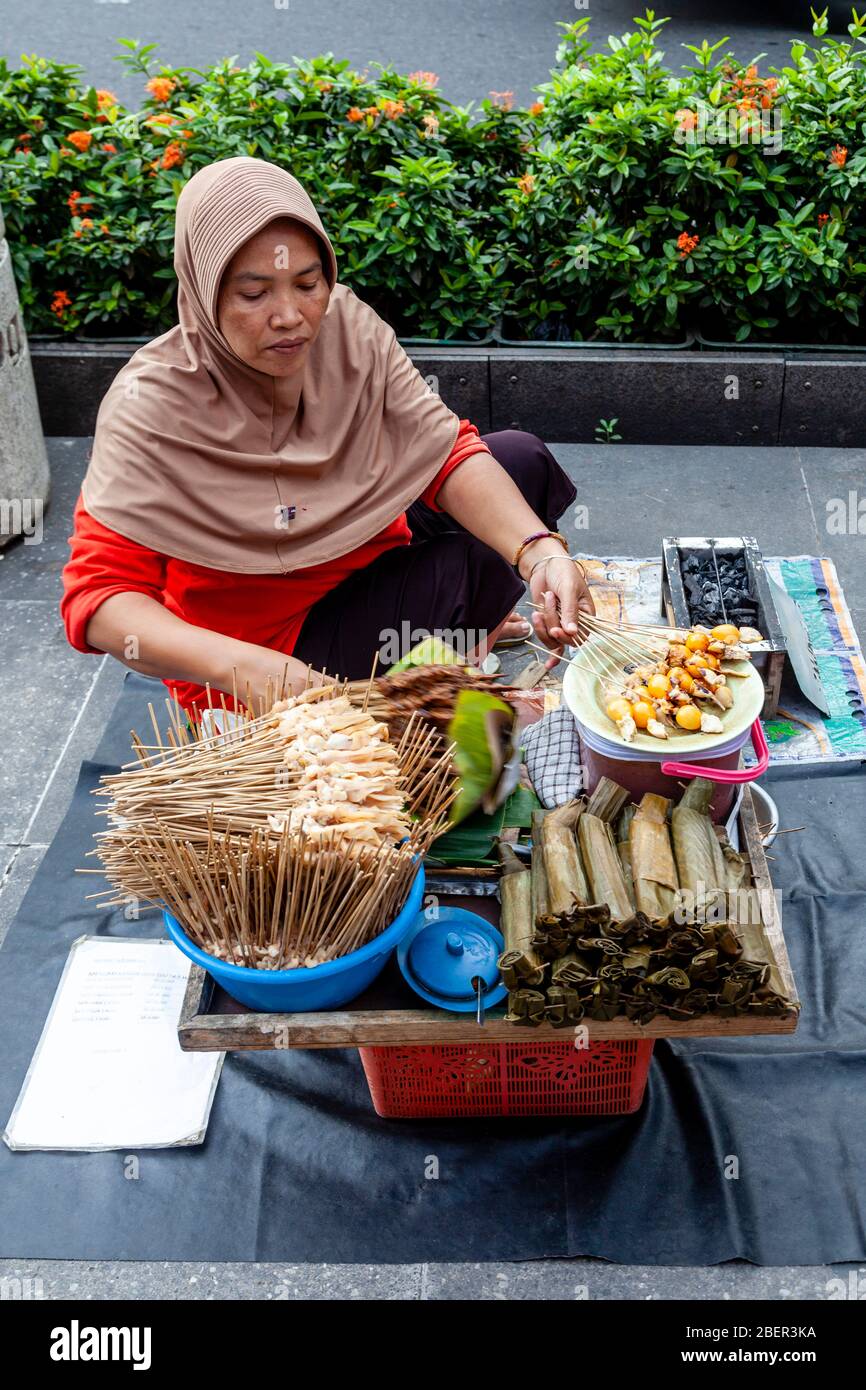 An Indonesian Woman Selling Snacks In Malioboro Street, Yogyakarta, Indonesia. Stock Photo